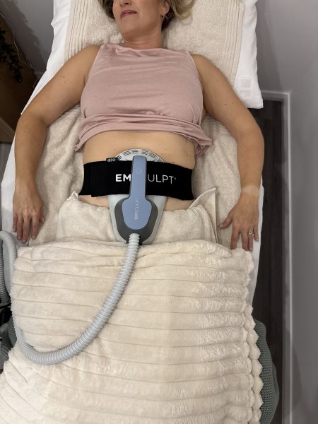 A woman having an Emsculpt core session on her tummy at The Effortless Clinic in Gungahlin