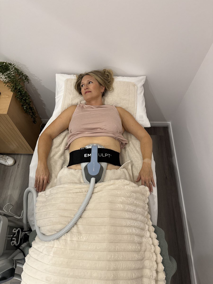 Client lying on the treatment bed with the Emsculpt abdomen applicator at The Effortless Clinic in Gungahlin