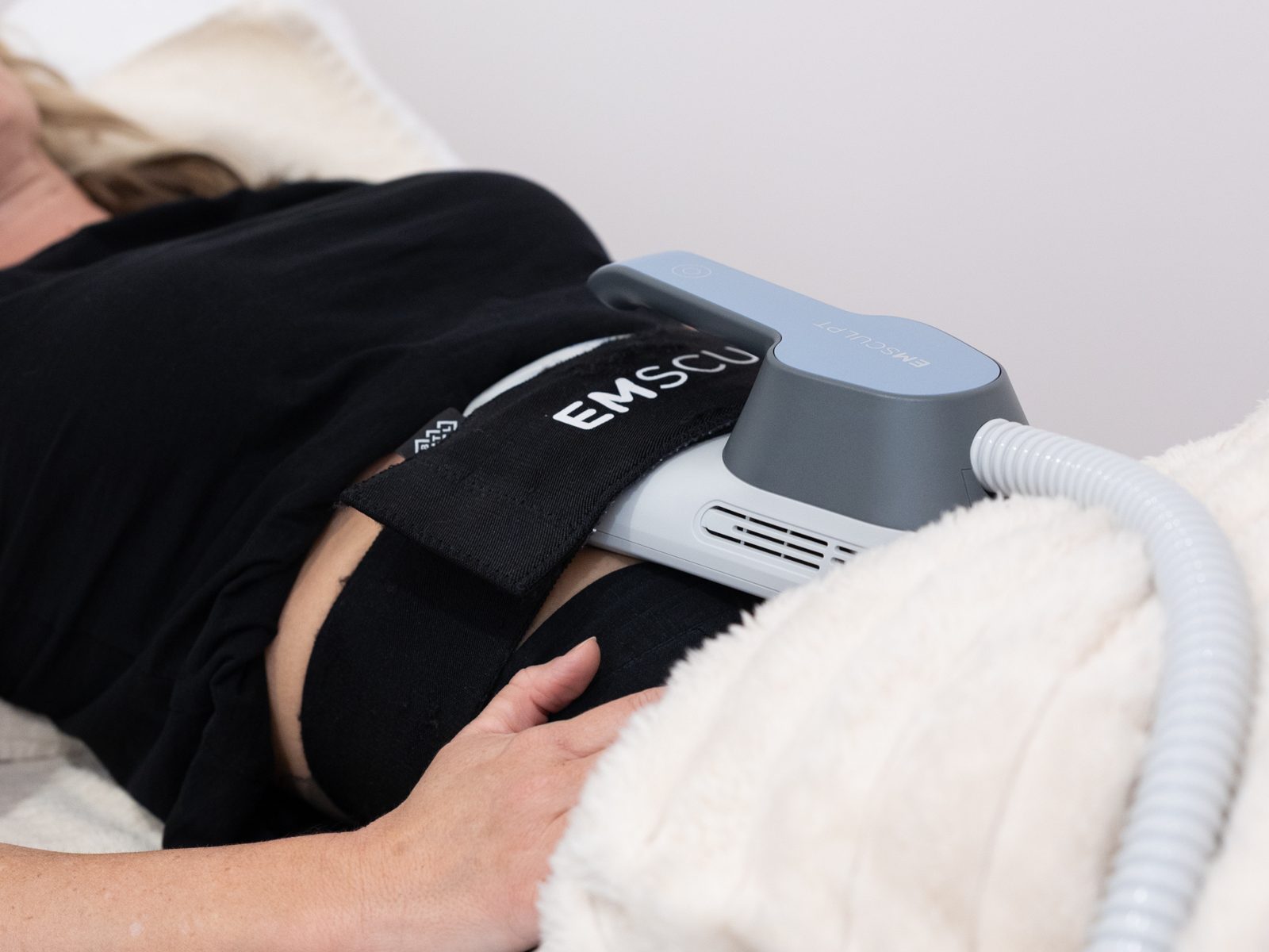 Emsculpt applicator on a client’s tummy during a treatment at The Effortless Clinic, Gungahlin