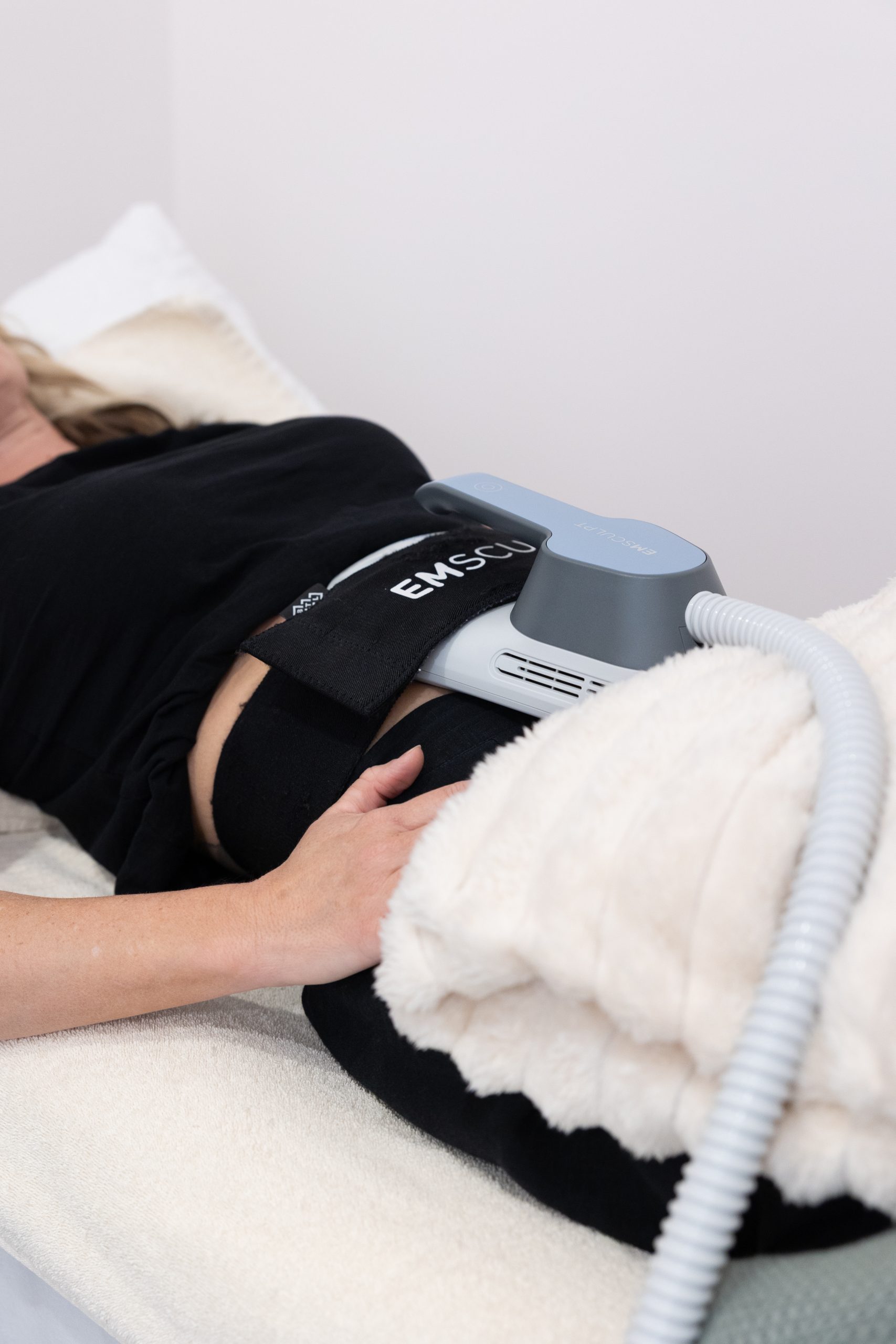 Emsculpt applicator on a client at The Effortless Clinic